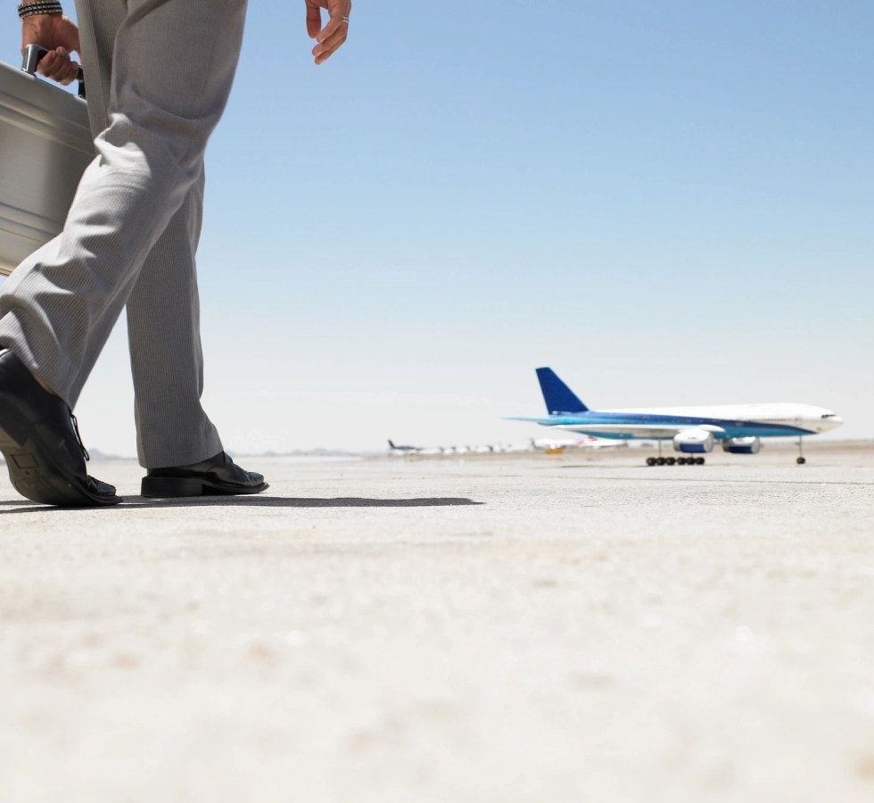 Two men standing on a runway near an airplane.