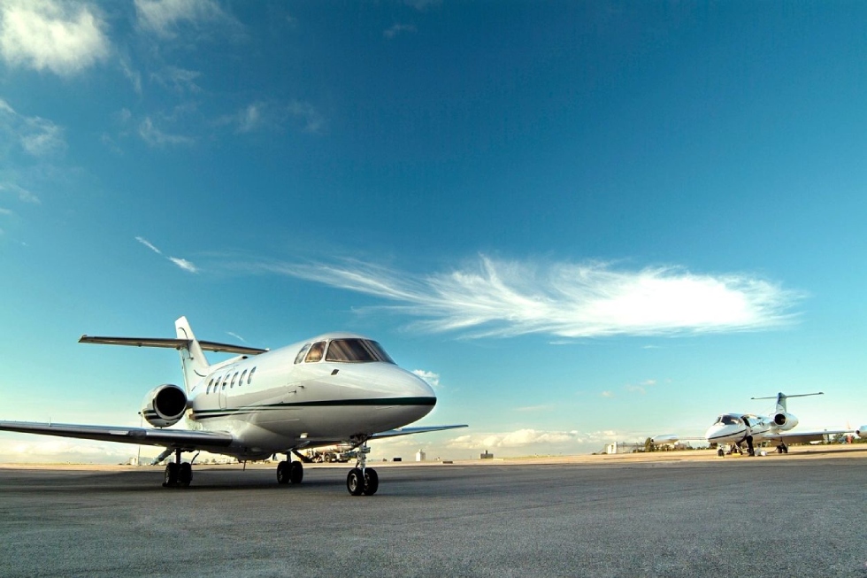 A white jet airplane sitting on top of an airport runway.