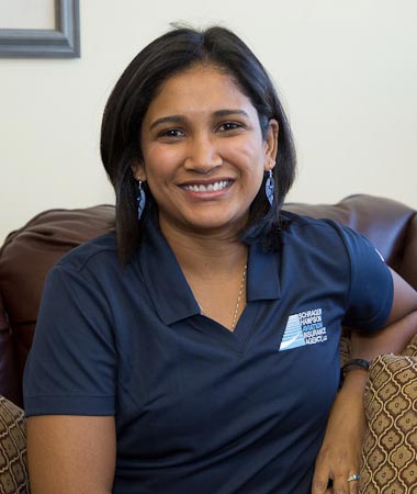 A woman sitting on top of a couch in front of a wall.