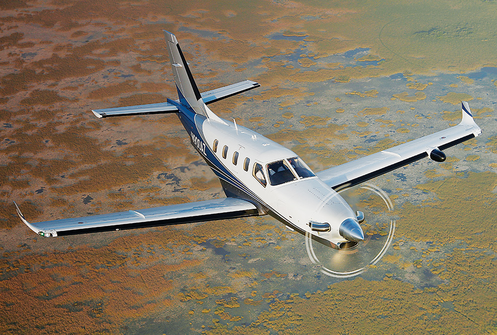 A small plane is flying over the water.