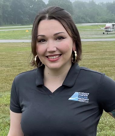 A woman in black shirt standing on grass.